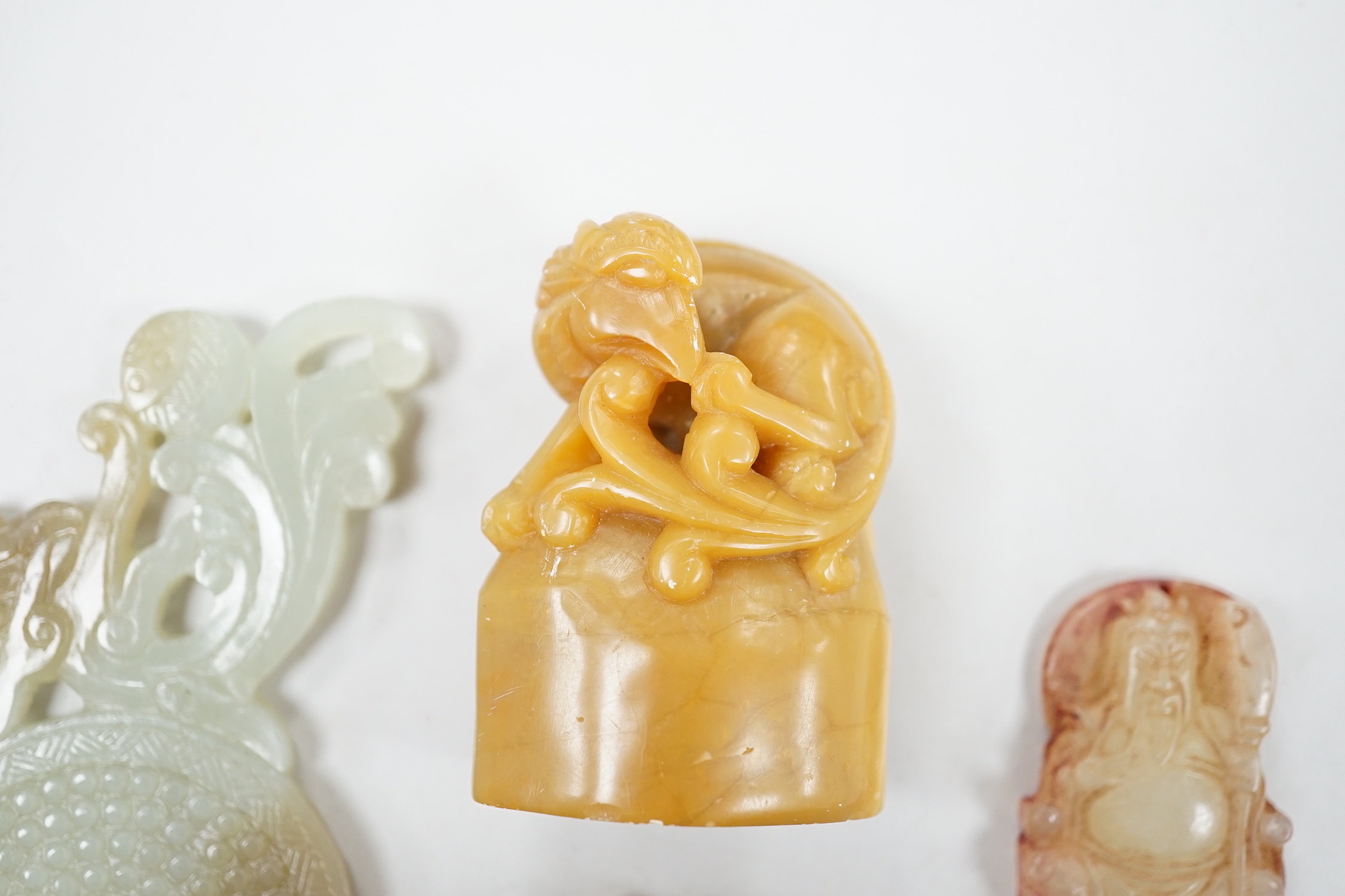 A collection of Chinese jade and soapstone carvings, largest a carved panel 11cm long